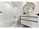Stylish bathroom with white tile, gold fixtures, and a modern vanity with drawers at 16671 Red Cliff Cir, Morrison, CO 80465