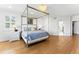 Spacious bedroom with a four-poster bed, hardwood floors, and large windows providing natural light at 16671 Red Cliff Cir, Morrison, CO 80465
