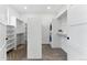 Spacious walk-in closet with custom shelving, hanging rods and integrated washer and dryer units at 16671 Red Cliff Cir, Morrison, CO 80465