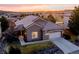Stunning sunset aerial view of a brown two-story home with a large tile roof and attached two-car garage at 16671 Red Cliff Cir, Morrison, CO 80465
