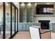 Cozy living area with built-in cabinets, fireplace, hardwood flooring, and sliding doors to the outdoor patio at 16671 Red Cliff Cir, Morrison, CO 80465