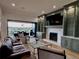 Inviting living room with a fireplace, built-ins, and a seamless indoor-outdoor flow to a scenic balcony at 16671 Red Cliff Cir, Morrison, CO 80465