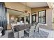 A covered patio with an outdoor dining table and a view of the open-concept living area at 16671 Red Cliff Cir, Morrison, CO 80465