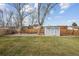 Spacious backyard featuring a well-maintained lawn, wooden fence, and storage shed at 11125 W Alamo Pl, Littleton, CO 80127
