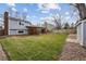 Large backyard featuring a patio, shed, green grass, and a wooden fence at 11125 W Alamo Pl, Littleton, CO 80127