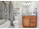 Bathroom with wood vanity, shower-tub combo, and neutral decor at 11125 W Alamo Pl, Littleton, CO 80127