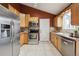Well-lit kitchen with stainless steel appliances and light wood cabinets at 11125 W Alamo Pl, Littleton, CO 80127