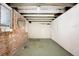 Unfinished basement featuring exposed brick, and visible ceiling beams, ready for customization at 130 S Humboldt St, Denver, CO 80209