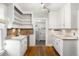 Well-lit kitchen featuring white cabinets, open shelving, and hardwood floors at 130 S Humboldt St, Denver, CO 80209