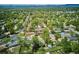 An aerial view shows a charming neighborhood with tree-lined streets and well-maintained homes nestled among lush greenery at 6410 Independence Way, Arvada, CO 80004