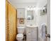 Well-lit bathroom features white fixtures, a shower with a bright curtain, and a decorative mirror and artwork at 6410 Independence Way, Arvada, CO 80004