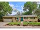 Charming single-story home with a well-maintained lawn, a blue door, and an attached garage at 6410 Independence Way, Arvada, CO 80004