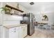 Bright kitchen boasts stainless steel appliances, granite countertops, and floating wooden shelves for stylish storage at 6410 Independence Way, Arvada, CO 80004