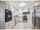 Bright kitchen featuring white cabinets, stainless steel appliances, and tiled flooring at 6410 Independence Way, Arvada, CO 80004