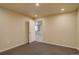 Finished basement space features neutral paint, recessed lighting, and a doorway at 13941 E Whitaker Dr, Aurora, CO 80015