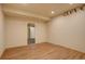 Finished basement space showcasing wood-look floors, recessed lighting, and a doorway at 13941 E Whitaker Dr, Aurora, CO 80015