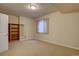 Finished basement room with neutral carpeting, built-in shelves, and a window at 13941 E Whitaker Dr, Aurora, CO 80015