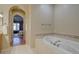Elegant bathroom showcasing a soaking tub with tile accents, and access to primary bedroom at 13941 E Whitaker Dr, Aurora, CO 80015