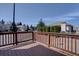View from wood deck overlooking a quiet residential street lined with mature trees and well-maintained landscaping at 13941 E Whitaker Dr, Aurora, CO 80015