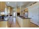 Bright kitchen features a central island with cooktop, granite countertops, and wood cabinets at 13941 E Whitaker Dr, Aurora, CO 80015
