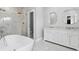 Elegant bathroom features a freestanding tub, glass-enclosed shower, and double vanity with round mirrors at 2111 S Franklin St, Denver, CO 80210