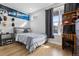 Bright bedroom with light hardwood floors features a window with a view, comfortable bed, and stylish decor at 2111 S Franklin St, Denver, CO 80210