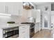 Bright kitchen featuring white cabinets, stainless steel appliances, and marble countertops at 2111 S Franklin St, Denver, CO 80210
