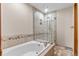 Bright bathroom features a soaking tub, a tiled shower, and neutral colors at 7712 S Monaco E Cir, Centennial, CO 80112