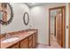 Bathroom with double vanity, granite countertops, and ornate mirrors at 7712 S Monaco E Cir, Centennial, CO 80112