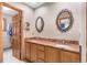 Bathroom with double vanity, granite countertops, and ornate mirrors at 7712 S Monaco E Cir, Centennial, CO 80112