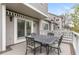 View of an outdoor deck with patio seating, an awning, and a sliding glass door leading inside the home at 7712 S Monaco E Cir, Centennial, CO 80112