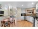 Eat-in kitchen showcasing granite counters, white cabinetry, stainless appliances and natural light at 7712 S Monaco E Cir, Centennial, CO 80112