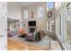 Bright living room with hardwood floors, fireplace, large windows, and modern furnishings at 7712 S Monaco E Cir, Centennial, CO 80112
