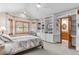 Spacious bedroom with built-in bookshelves and exterior window with wooden shutters at 7712 S Monaco E Cir, Centennial, CO 80112