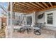 A covered patio with brick flooring and wrought-iron furniture, offering a cozy outdoor space at 7712 S Monaco E Cir, Centennial, CO 80112