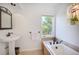 Serene bathroom with a soaking tub, pedestal sink, and nature views at 160 Bristlecone Way, Boulder, CO 80304