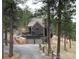 Charming home nestled amongst the trees, showcasing its unique architecture and two-car garage with a sloped driveway at 160 Bristlecone Way, Boulder, CO 80304