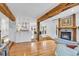 Open-concept living room with hardwood floors, exposed beams, fireplace, and sightlines into the kitchen at 160 Bristlecone Way, Boulder, CO 80304