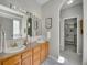 Bathroom with double sinks, a large mirror, and an arched doorway to the walk-in closet at 946 Champion Cir, Longmont, CO 80503