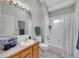 This bathroom has a tub-shower combo, a toilet, and a vanity sink with a wooden cabinet and backsplash at 946 Champion Cir, Longmont, CO 80503