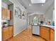 Sunlit kitchen featuring hardwood floors, light wood cabinets, and a view into the dining area at 946 Champion Cir, Longmont, CO 80503