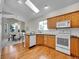 Well-lit kitchen featuring hardwood floors, oak cabinets, and modern appliances at 946 Champion Cir, Longmont, CO 80503