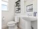 Clean, modern bathroom with a pedestal sink, toilet, and decorative shelving at 2080 Alcott Way, Broomfield, CO 80023