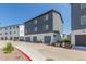 Exterior view of modern three-story townhomes featuring attached garages, gray siding and well maintained grounds at 2080 Alcott Way, Broomfield, CO 80023