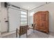 Flex room with large armoire, accent chairs, and a garage door with translucent windows at 2080 Alcott Way, Broomfield, CO 80023