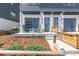 Inviting townhouse front porch with blue garage doors, green rocking chairs, and landscaped walkway at 2080 Alcott Way, Broomfield, CO 80023