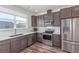 Well-lit kitchen showcasing stainless steel appliances, sleek cabinets, and bright countertops with a view at 2080 Alcott Way, Broomfield, CO 80023