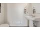 Stylish powder bath with pedestal sink, modern light fixture and framed art at 2080 Alcott Way, Broomfield, CO 80023