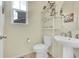 Charming powder room with pedestal sink, decorative shelving, and a window at 4884 St Vrain Rd, Firestone, CO 80504