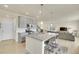 Modern kitchen with stainless steel appliances, large island and breakfast bar open to the adjacent living room at 4884 St Vrain Rd, Firestone, CO 80504